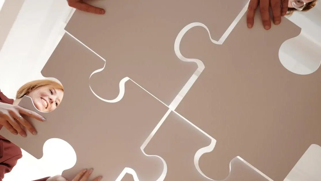 Diverse group assembling puzzle pieces, illustrating teamwork in creating a resume for volunteer work