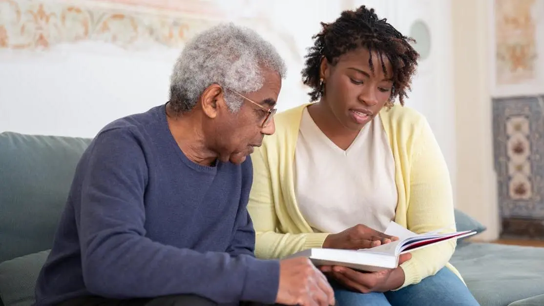 Caregiver and senior man sharing conversation while volunteering at a care home