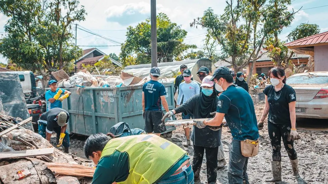Work as volunteer cleaning up debris after disaster, demonstrating teamwork and community support