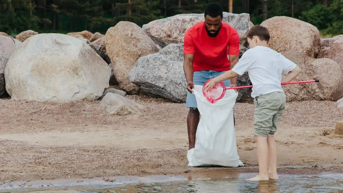 Volunteers clean a beach with net and bag, showcasing volunteer jobs abroad and environmental impact