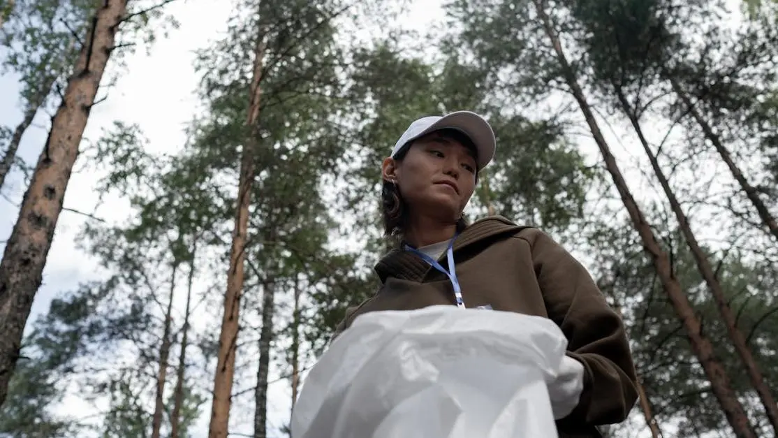 Woman picking up litter in a forest, highlighting weekend volunteer opportunities in conservation