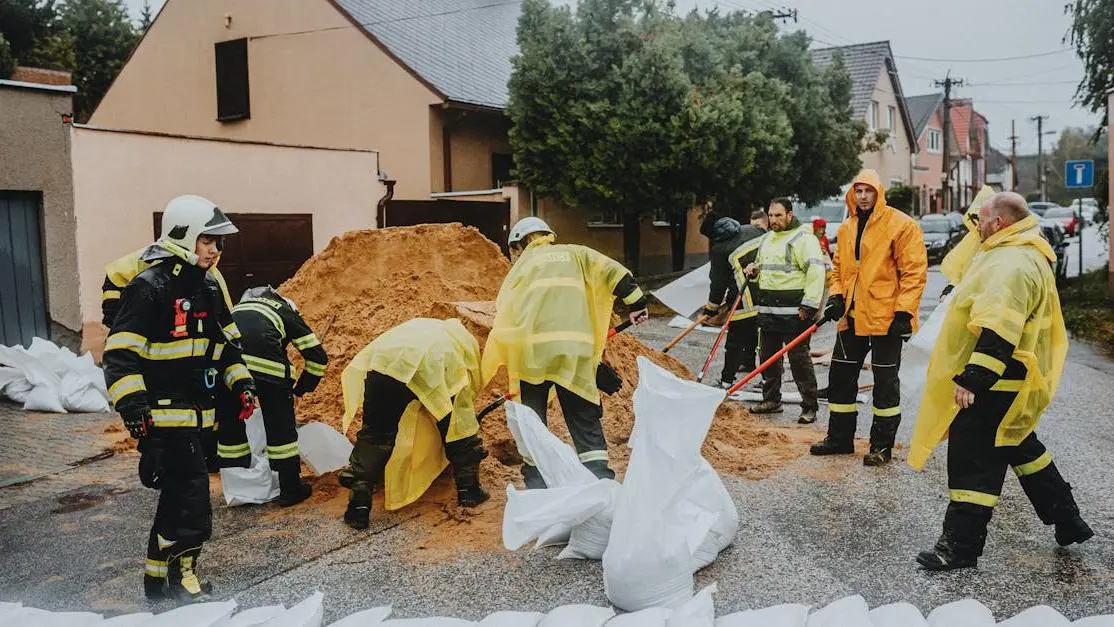 Emergency volunteers in crisis response filling sandbags for disaster aid during heavy rain