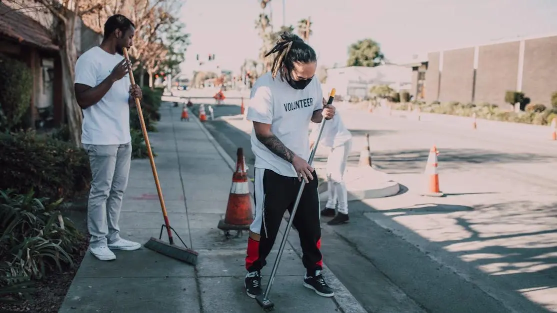 Volunteers cleaning a city sidewalk, showcasing volunteer and community service and teamwork