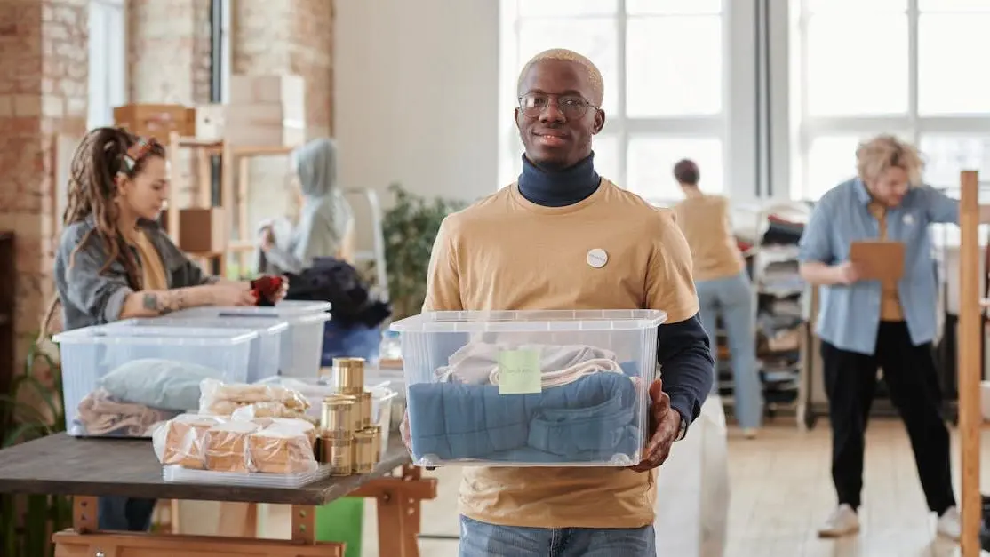 Volunteers sorting donated clothes at a busy volunteer center indoors
