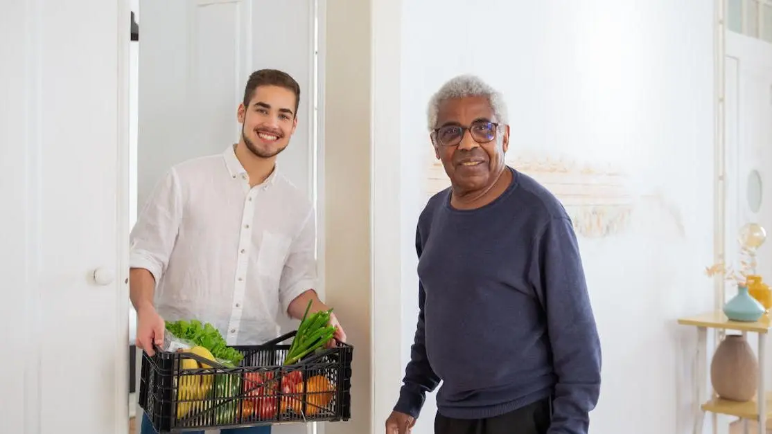 Senior man receives fresh produce from young volunteer, highlighting food bank volunteer opportunities